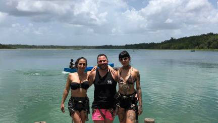 Visitors standing on a wooden dock in a lagoon