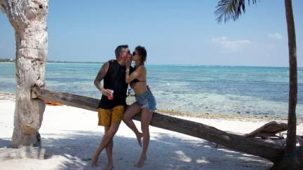 Couple sitting on a wood ledge at the beach