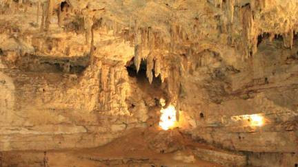 Visitors standing on a rock platform on a cave cenote